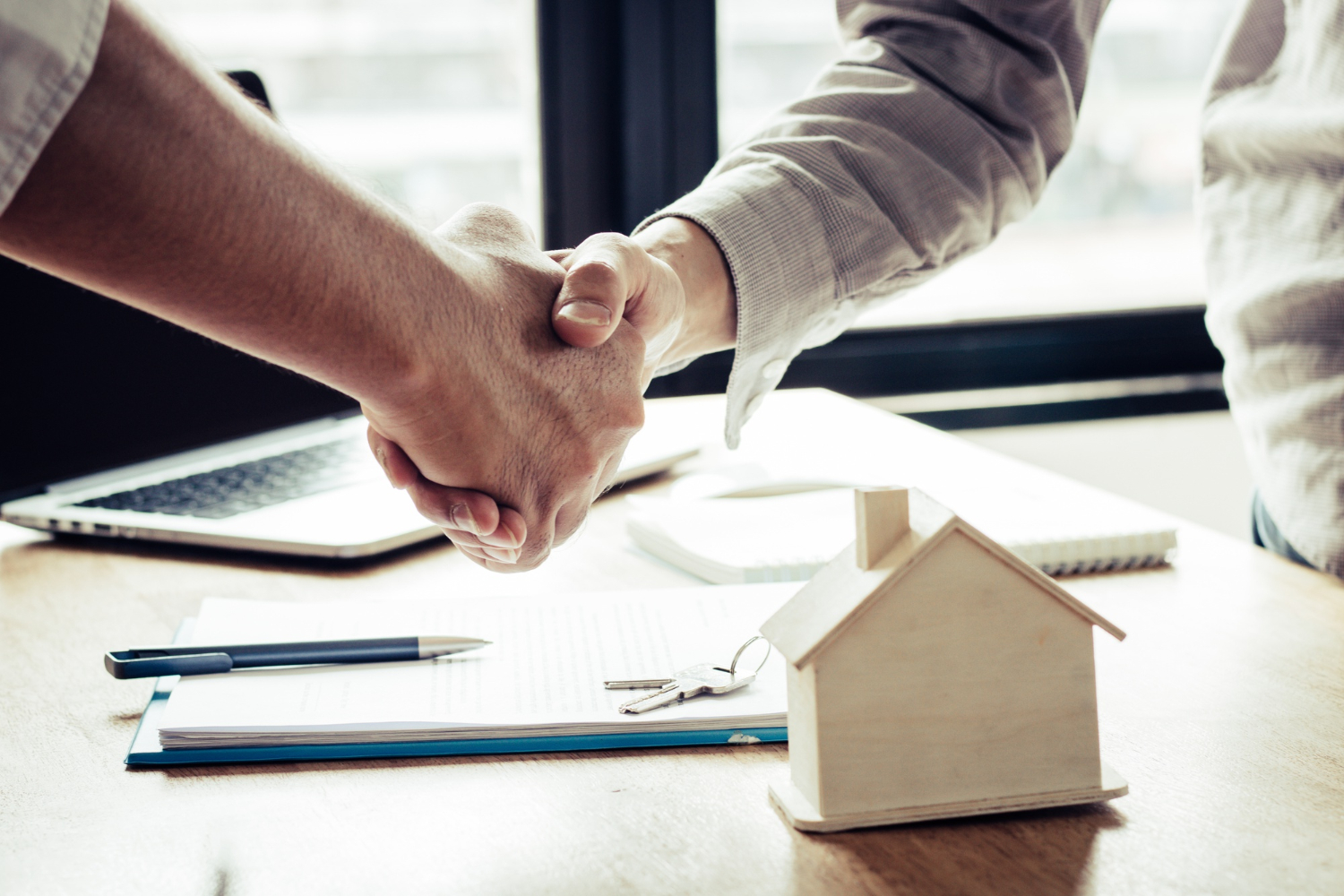 deux hommes se serrent la main apres une transaction immobiliere reussie